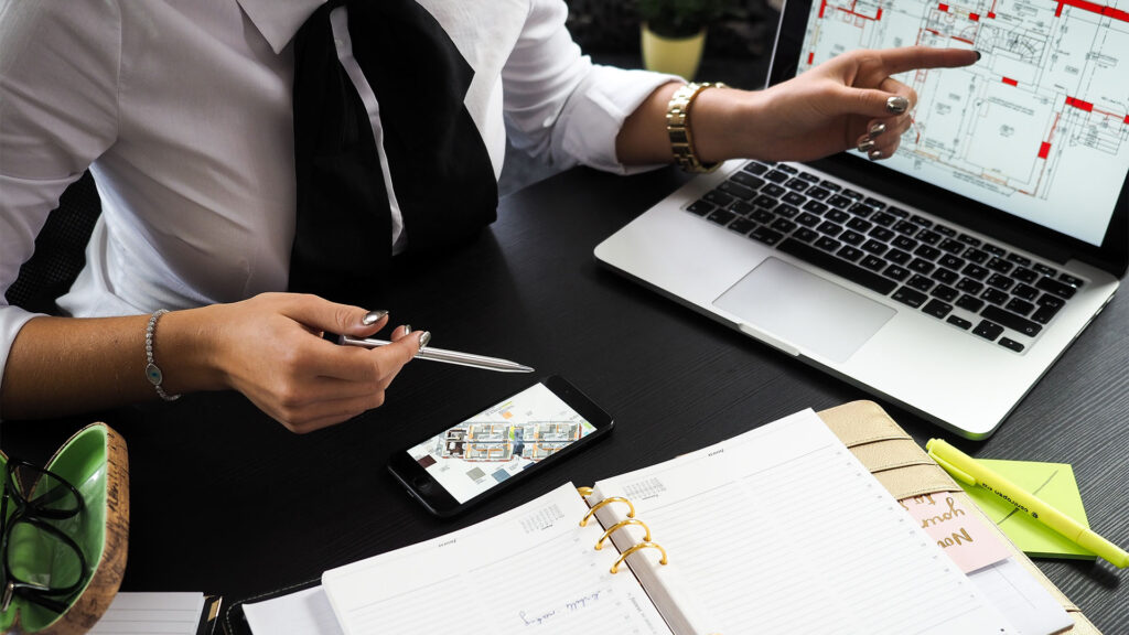 professional-consulting-services - woman pointing to a blueprint on a laptop